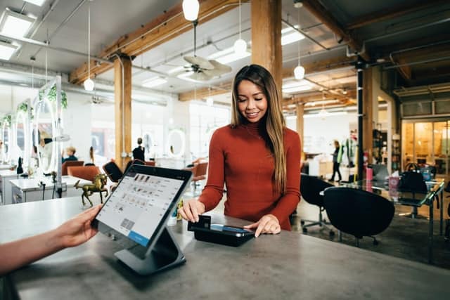 woman using a card machine in a shop